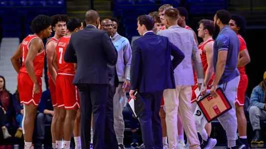 Men's Basketball team huddle with the players and coaches during a timeout