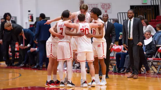 men's basketball starters huddle up in a circle