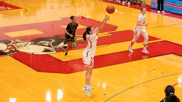 Photo of women's basketball junior Inés Monteagudo shooting a three-pointer against UMaine Fort Kent.