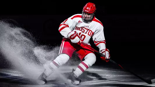 Jonathan Morello sprays snow as he stops on the blue line after being introduced before a BU hockey game
