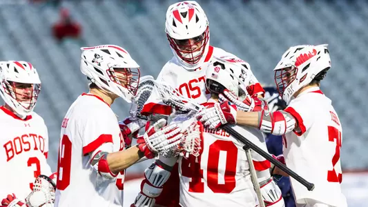 Men's lacrosse players celebrate a goal