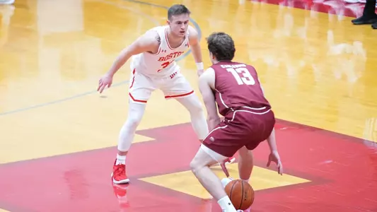 Ben Roy crouches to defend a Colgate player dribbling the ball up the court.