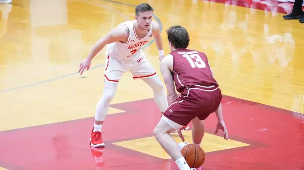 Ben Roy crouches to defend a Colgate player dribbling the ball up the court.