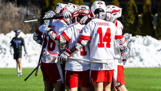 Men's lacrosse players celebrate a goal against Air Force