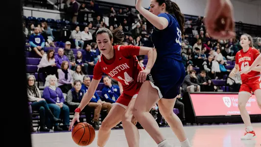 Photo of women's basketball sophomore Inés Monteagudo dribbling against a Holy Cross defender.