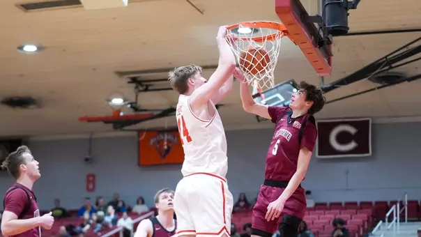 Ben Defty hits a slam dunk with a Lafayette defender trying to block his shot attempt.