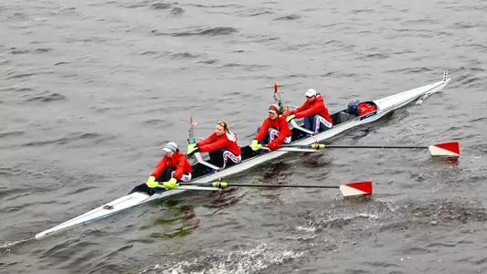 Photo of a BU Women's Rowing Four racing on the Charles River.