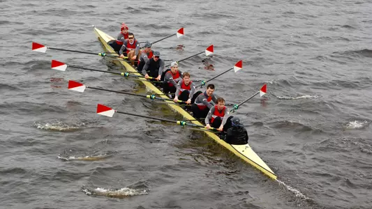 Photo of the BU Men's Rowing 3V8 racing on the Charles River.