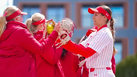 BU softball players high-five one another during lineup introduction.