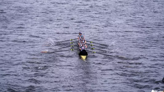 Photo of a BU Men's Rowing 8 racing on the Charles River.