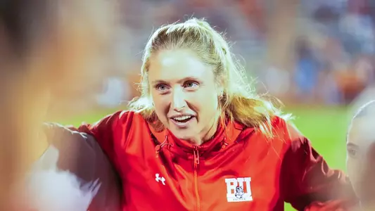 Photo of BU women's soccer coach Megan Burke addressing the team at the NCAA Tournament.