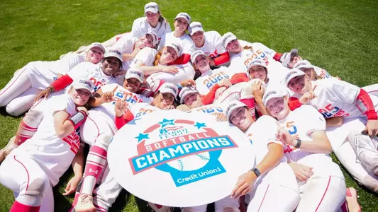 2025 Patriot League champion softball team poses for a group photo around the PL champion sign