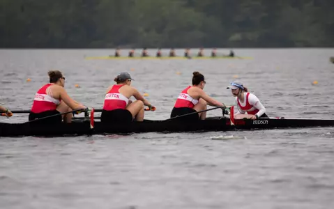 Varsity eight boat races down the lake on the first day of the NCAA Championships