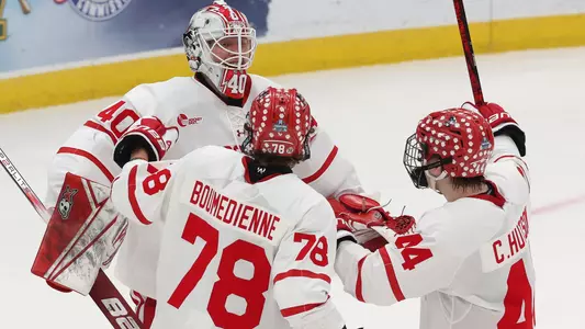 Sascha Boumedienne and Cole Hutson celebrate with goaltender Mikhail Yegorov after BU defeated Penn State in the Frozen Four