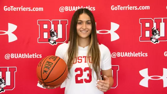 Photo of incoming women's basketball sophomore Rose Azmoudeh in a white BU jersey holding a basketball.