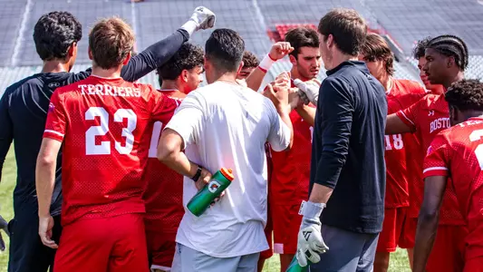Men's Soccer players in red huddle up before competing in an intrasquad scrimmage