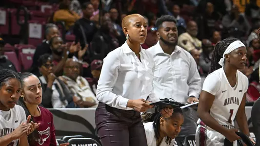 Photo of now women's basketball director of operations Capree Garner coaching on the UMES bench during a game.