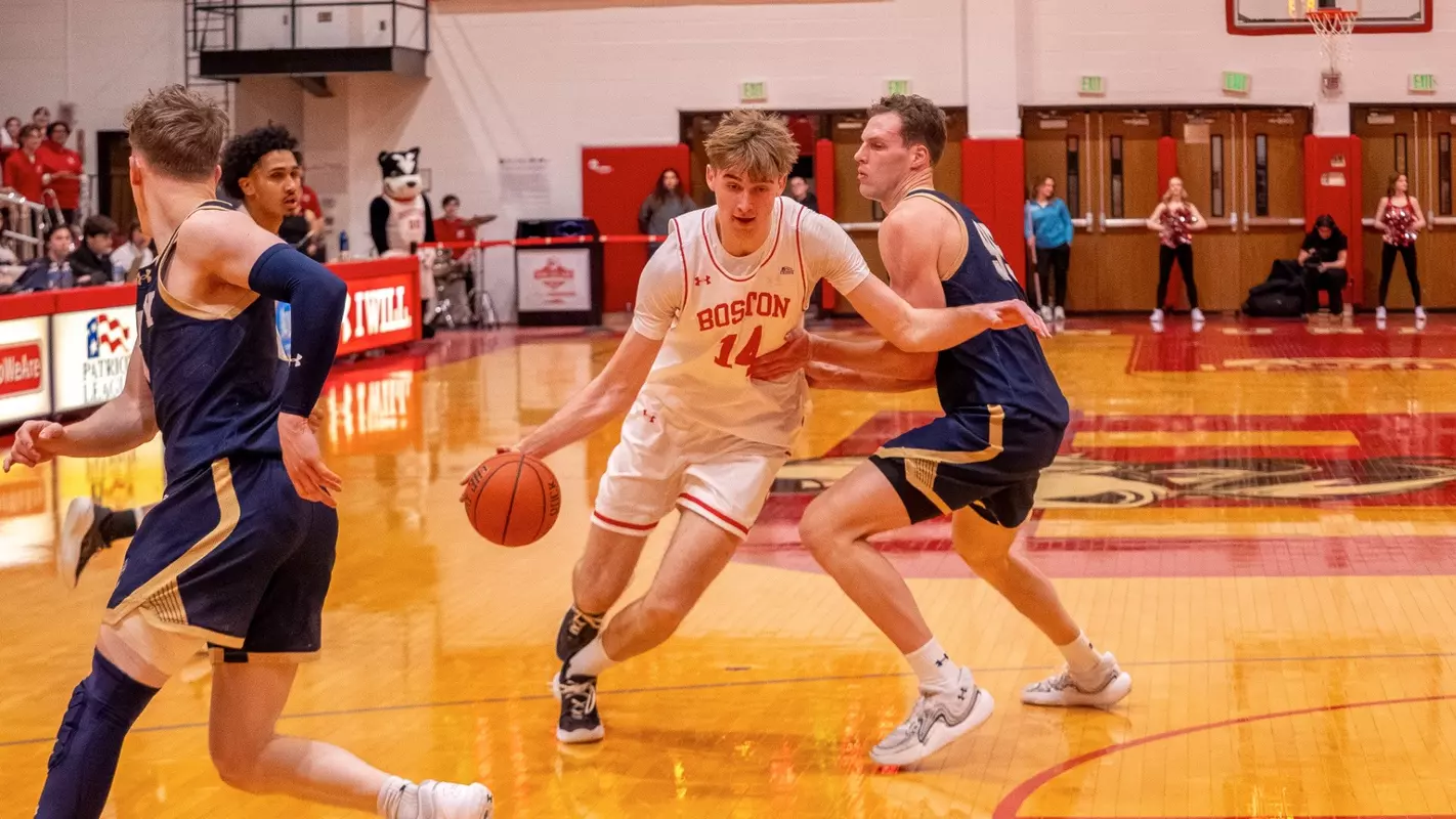 Ben Defty dribbles toward the hoop while defended by a Navy player