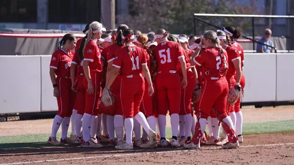 Boston University softball team huddles together at the end of a half inning