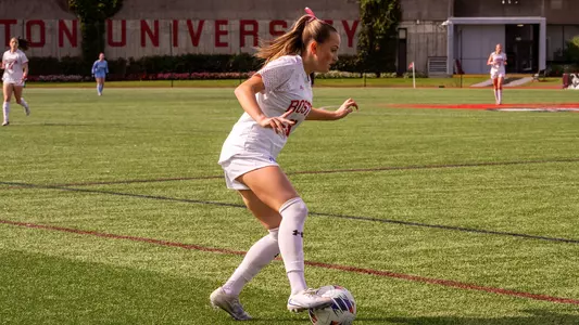 Photo of BU women's soccer junior Olivia Avellar dribbling the ball at Nickerson Field.