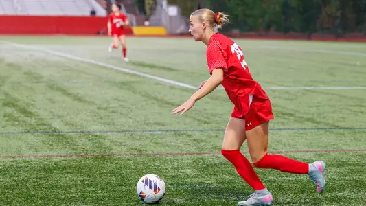 Photo of BU women's soccer junior Alli Powderly dribbling the ball at Nickerson Field.