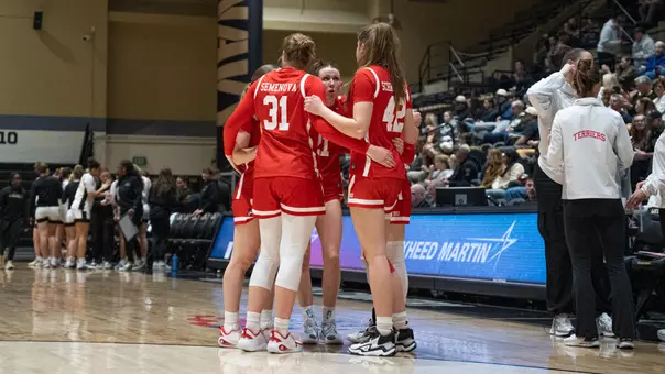 Photo of a BU Women's Basketball team huddle at Army West Point.