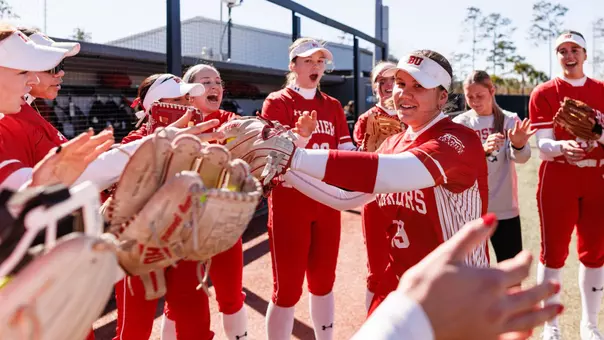 BU softball team players high five one another during starting lineup announcement