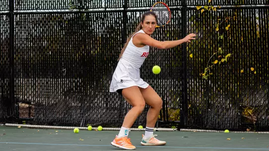 Gabreilla Mikaul winds up to hit a forehand shot while looking at the tennis ball