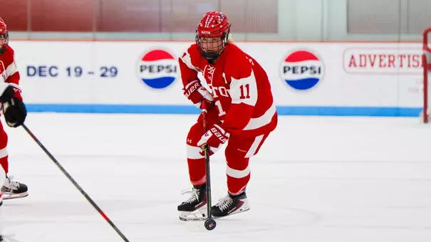 Sydney Healey skating with the puck in a red jersey