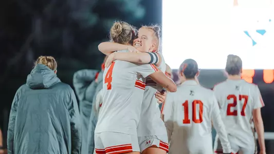 Photo of BUWomen's Soccer seniors Margy Porta and Mackenzie Stickelman embracing following a Patriot League semifinal win.