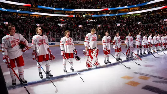 Men's ice hockey players standing on the blue line during the national anthem at the Beanpot