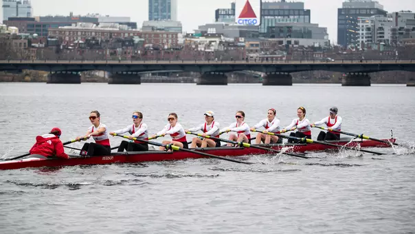 Photo of the BU Lightweight Rowing Varsity 8 racing on the Charles River.