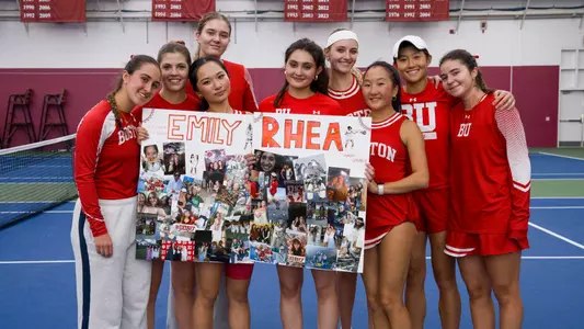 Women's tennis team poses with seniors and their senior day posters