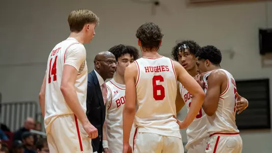 BU men's basketball head coach Joe Jones huddles with the five Terriers on the court.