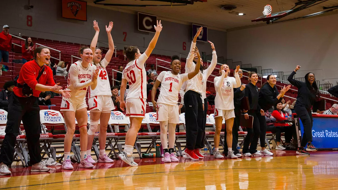 Photo of the BU Women's Basketball team bench celebrating at Case Gym.