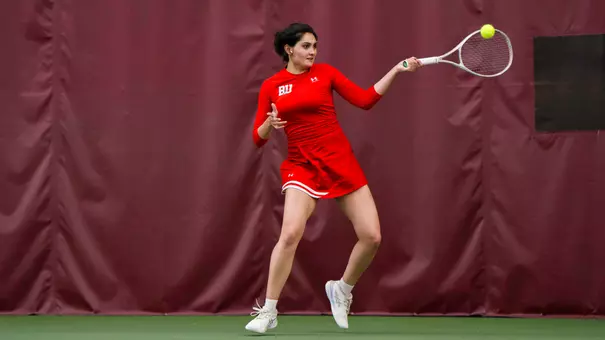 Rhea Rai hits a forehand on an indoor tennis court
