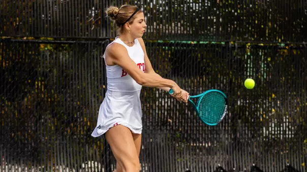 Ellie Gyuro hitting the tennis ball on an outdoor court