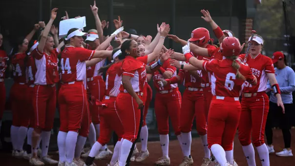 BU softball team forms a home run celebration tunnel for Megan Coyle to go thru into the dugout