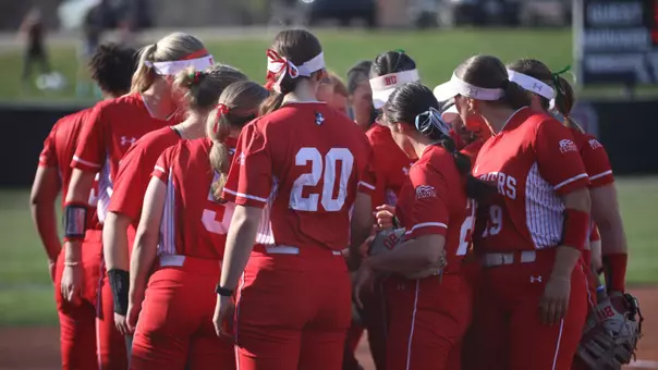 BU softball team huddles together at Harvard.