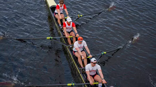 Photo of the BU Men's Rowing Varsity 8 racing on the Charles River.