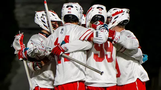 Men's lacrosse players celebrate a goal