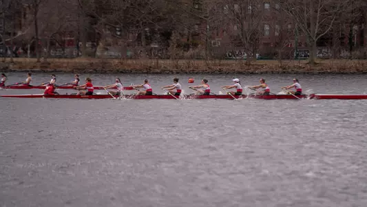 Photo of the BU Lightweight Rowing Varsity 8 racing MIT on the Charles River.