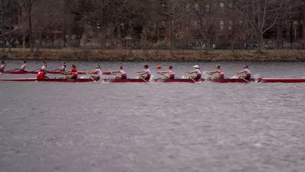 Photo of the BU Lightweight Rowing Varsity 8 racing MIT on the Charles River.