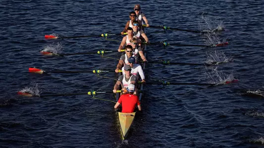 Photo of the BU Men's Rowing Third Varsity 8 racing on the Charles River.