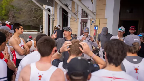 Photo of a BU men's rowing team huddle.