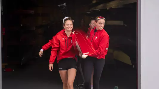 Photo of a BU Lightweight Rowing preparing to leave the DeWolfe Boathouse.