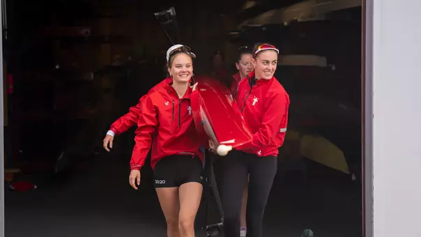Photo of a BU Lightweight Rowing preparing to leave the DeWolfe Boathouse.