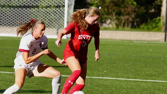 Photo of BU women's socce senior Ava Maguire working against a Boston College defender.