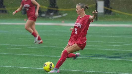 Photo of BU women's soccer junior Alli Powderly kicking the ball at Bryant.