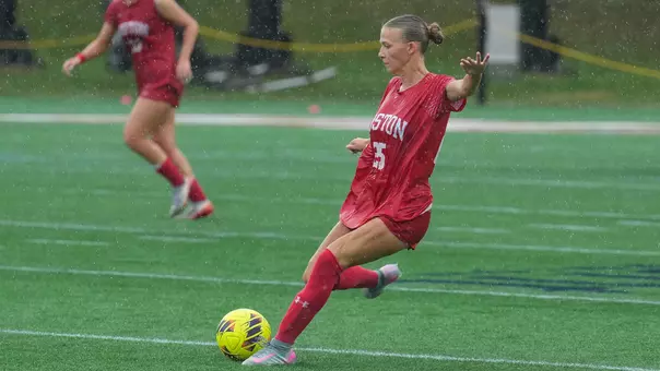 Photo of BU women's soccer junior Alli Powderly kicking the ball at Bryant.